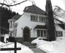 Front elevation of the Superintendent's Residence, showing the combination of rough-finished stucco with woodwork and stone, ca. 1991.; Agence Parcs Canada / Parks Canada Agency, ca./vers 1991.