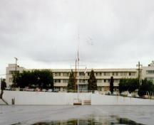 Façade latérale du bâtiment 34, qui montre l’agencement des fenêtres de métal en longues rangées, ce qui accentue le caractère horizontal du bâtiment, 1993.; Department of National Defence / Ministère de la Défense nationale, 1993.