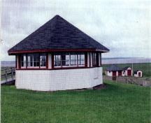 Vue du pavillon de l'abri de pique-nique , qui montre le revêtement de planches posées à l’horizontale et les rangées de fenêtres, 1996.; Agence Parcs Canada / Parks Canada Agency, 1996.