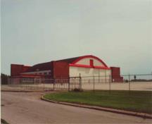 Hangar 11, montrant l'élévation ouest sur la droite et l'élévation nord sur la gauche. À l'extrême gauche, la section d'un étage qui a été ajouté à l'angle nord-ouest vers la fin des années 1950, début des années 1960 est visible, 2001.; Agence Parcs Canada / Parks Canada Agency, E. Tumak, 2001.