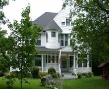 Formal frontal orientation of the house to Maple Street including surrounding grass yard.; PNB 2005