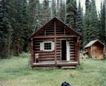 View of the main entrance to the Middle Forks Warden Patrol Cabin, showing the rustic architecture practiced within National Parks, 1997.; Parks Canada Agency / Agence Parcs Canada, 1997.