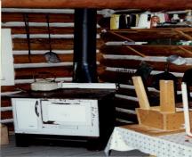 Interior view of the Middle Forks Warden Patrol Cabin, showing the interior objects and its walls constructed of peeled logs, 1997.; Parks Canada Agency / Agence Parcs Canada,  1997.
