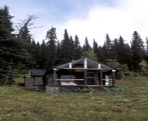 View of the exterior of the Floe Lake Warden Patrol Cabin, showing the simple, well-proportioned composition of this rectangular building which features a medium-pitched gable roof, 2005; Parks Canada Agency / Agence Parcs Canada, C. Siddal, 2005.