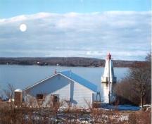 View of the Sandy Point Lighthouse at the inner entrance to Shelburne Harbour.; Public Works and Government Services Canada / Travaux publics et Services gouvernementaux Canada.