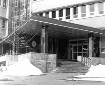 Vue générale de l'édifice de la Commission géologique du Canada, qui montre l’entrée principale d’un étage, formée de pans horizontaux et verticaux comblés de verre, 1994.; Parks Canada Agency / Agence Parcs Canada, Graham, 1994.