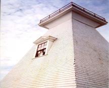 Detail view of the Mabou Lighthouse showing the classical proportions and detailing including the pedimented window and door openings, six-over-six sash windows and cornice, 2002.; Public Works Canada / Ministère des Travaux publics, 2002.