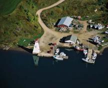 Aerial View of Mabou Lighthouse and wharf putting an emphasis on its symbolic value to the communities of Mabou Harbour as a reminder of the dependence of the area on ocean-based activities, 2001.; Department of Fisheries & Oceans Canada/Département de pêches et océans Canada, 2001.