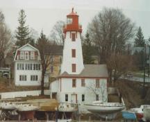 Façade latérale du phare, qui montre la résidence d’un étage et demi coiffé d’un toit à deux versants et qui est bien intégrée au phare, 1990.; Transport Canada / Transports Canada, 1990.