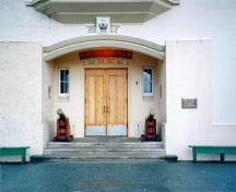 Vue des détails de la porte d'entrée principale du pavillon Grant avec ses portes doubles encadrées par des fenêtres, disposée en retrait, avec un arc segmentaire, 1995.; Parks Canada Agency / Agence Parcs Canada, L. Maitland, 1995.