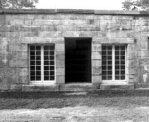 Front facade of the West Front casemates portraying its simple, unadorned stone façade, with a door flanked by two side windows, 1989.; Parks Canada Agency / Agence Parcs Canada, 1989.