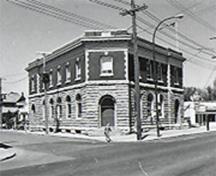 General view of Postal Station "B," showing the classical order of the symmetrical façades that includes the rusticated stone first floor, the brick second floor, and a projecting metal cornice and brick parapet trimmed in stone, 1971.; Canadian Inventory of Historic Buildings/Inventaire des Bâtiments Historiques du Canada, 1971.