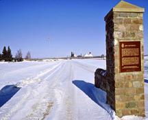 General view of the main entrance to Fort Battleford National Historic Site of Canada showing the Historical Sites and Monuments Board of Canada plaque and depicting the fort in the background, 1991.; Parks Canada Agency / Agence Parcs Canada, D. McArthur, 1991.