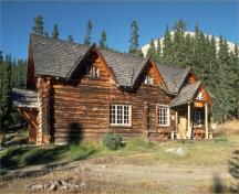 General view of the Skoki Ski Lodge emphasizing its steeply pitched gable roof with multiple dormers, 1994.; Parks Canada / Parcs Canada 1994