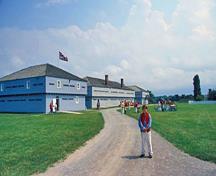 Vue panoramique du Blockhaus 3 mettant de l'emphase sur sa conception simple et les matériaux utilisés, qui s’harmonisent avec les blockhaus et le pavillon voisin et avec les autres bâtiments situés dans ce cadre à caractère militaire, 2003.; Parks Canada Agency / Agence Parcs Canada, B. Morin, 2003.