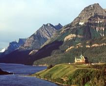 Vue panoramique de l'Hôtel Prince of Wales mettant de l'emphase sur son emplacement spectaculaire sur un promontoire dominant le lac Waterton et ses points de vue vers les prairies, montagnes, et lacs environnants, 1999.; Parks Canada Agency / Agence Parcs Canada, J.F. Bergeron. 1999.