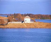Panoramic view of the Murney Tower emphasizing its setting on the natural triangular projection of Murray Point and the viewscapes to the other three martello towers arranged around the harbour and to Lake Ontario, 1994.; Parks Canada Agency / Agence Parcs Canada, J. Butterill, 1994.