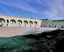 General view of the Fort Henry parade grounds showing the surviving elements of the original fortification, including the design, form and materials of the built and landscaped components, 1995.; Parks Canada Agency/Agence Parcs Canada, J. Butterill, 1995.