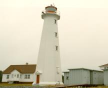 Vue générale du phare, qui montre le volume simple, soit une tour en béton blanche, octogonale et élancée, avec une corniche évasée sur laquelle repose une lanterne, 2000.; Transport Canada / Transports Canada, 2000.