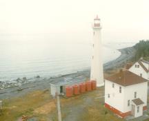 Façade du phare, qui montre le garde-fou peint de la galerie et la lanterne en métal à plusieurs faces, peinte en rouge, 2000.; Transport Canada / Transports Canada, 2000.