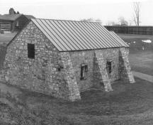 Rear view of the Powder Magazine, showing the exterior massing with reinforcing buttresses, 1989.; Parks Canada Agency / Agence Parcs Canada, 1989.