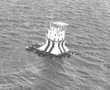 Vue aérienne de la Résidence démontrant la salle des radios sur le toit, le parapet et la lanterne qui est surmontée par un héliport décentré, 1988.; Canadian Coast Guard / Garde côtière canadienne, 1988.
