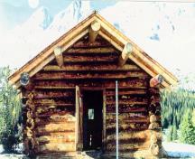 Front facade of the Halfway Hut showing the deep overhang above the cabin entrance.; Parks Canada Agency / Agence Parcs Canada, n.d.
