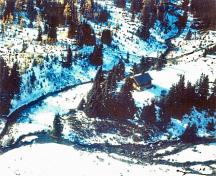 Aerial view of the Halfway Hut emphasizing the compatibility of the building's rustic form with the picturesque wilderness setting of the Ptarmigan Valley's alpine meadows and mountain peaks, 2000.; Western Canada Service Center / Centre de services de l'Ouest canadien, 2000.