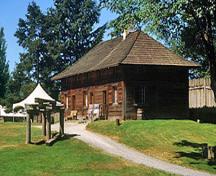 Corner view of the Servants' Quarters showing its one-and-a-half storey, hipped roof, rectangular structure that is five bays in length and two bays in width, 2002.; Parks Canada Agency / Agence Parcs Canada, M. Trepanier, 2002.