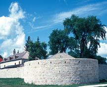 Vue générale de l'arrière du bastion sud-ouest montrant les murs en pierre, le toit recouvert de bardeaux de bois et le revêtement des lucarnes, 1997.; Parks Canada Agency / Agence Parcs Canada, S. Buggey, 1997