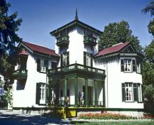 General view of Bellevue House showing the original Italianate proportions of its silhouette with a high square tower, balconies and a columned verandah, 1985.; Parks Canada Agency / Agence Parcs Canada, B Morin, 1985.