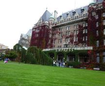 Vue générale de l'hôtel Empress, qui montre les jardins paysagés entourant l'hôtel, qui le séparent des zones urbaines plus denses, 2011.; Parks Canada Agency / Agence Parcs Canada, Andrew Waldron, 2011.