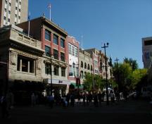 General view of Stephen Avenue, showing the regular pattern of large windows - either flat or round-headed - defining the street facade of each building, 2004.; Parks Canada Agency/Agence Parcs Canada, 2004.
