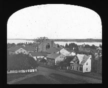 Shows new Wesleyan Church under construction in the 1860s.  The "L" shaped extension immediately to the left of the new church is the current 21-23 Prince Street building.; PEI Public Archives and Records Office, Smith Alley Collection, Accession #2702/29