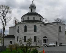 View from the street of the church and its particular shape; Parks Canada / Parcs Canada, 1984
