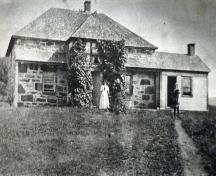 Front elevation with woman and child out front ca. 1900, MacRae-Bitterman House, Middle River, Cape Breton, NS.; Courtesy of the Beaton Institute, Cape Breton University.
