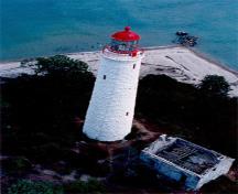 Aerial view of the Chantry Island Lighthouse showing its tall, round, slightly tapered form corbelled at the top to form a gallery and base for the lantern, 1990.; Canadian Coast Guard / Garde côtière canadienne, 1990.