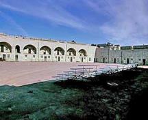 General view of the Fort Henry parade grounds showing the surviving elements of the original fortification, including the design, form and materials of the built and landscaped components, 1995.; Parks Canada Agency/Agence Parcs Canada, J. Butterill, 1995.