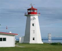 General view showing Cape Mudge Lighthouse showing its two foghorns protruding from an upper-level enclosed window, 2009.; Kraig Anderson - lighthousefriends.com