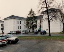 Façade ouest de l'édifice B-1, qui montre le rejeu des murs simple par la disposition et l’encadrement des fenêtres, 1993.; Department of National Defence / Ministère de la Défense nationale, 1993.