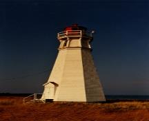 Vue en angle de l'arrière du phare de Cape Jourimain montrant la structure, la hauteur et les proportions équilibrées d’origine du bâtiment, 1990; Transport Canada | Transports Canada