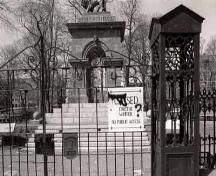 Alternate view of the Sebastopol memorial through the main entrance gate to the Old Burying Ground, 1993.; Agence Parcs Canada / Parks Canada Agency, 1993.