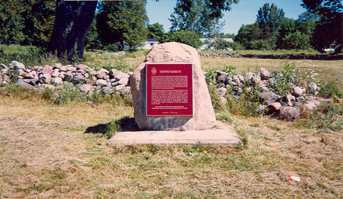 commemorative plaque and outlining rock walls