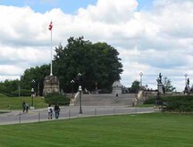 Vue générale de la terasse surélevée, qui montre le mur de soutènement, le porte-drapeau en pierre et le baie en saillie et les escaliers, situé à l'ouest de l'édifice du Centre, 2010; Parks Canada Agency / Agence Parcs Canada, Jamie Dunn, 2010.