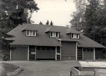 View of Wardens' Equipment Building, showing the broad hipped roof, with exposed rafter-ends and shingle-sided hip roofed dormers, 1984.; Agence Parcs Canada / Parks Canada Agency, 1984.