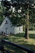 Corner view of the French People's House, showing its stone construction with crépi covered exterior walls, 1991.; Parks Canada Agency / Agence Parcs Canada, Christine Chartré, 1991.