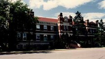 General view of the A Block, showing the strongly projecting central entryway, 1986.; Royal Canadian Mounted Police \ Gendarmerie royale du Canada, 1986.