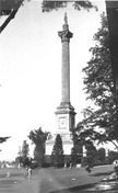 Vue du monument Brock, qui montre la forme haute et élégante du monument et sa volumétrie géométrique formée par une haute colonne circulaire reposant sur une base carrée, vers 1920.; Archives of Ontario| Archives publiques de l'Ontario, ca./vers 1920.