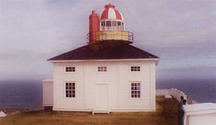 Vue générale du phare du cap Spear montrant l’expression des principes de la conception néoclassique dans les larges fenêtres rectangulaires régulières du rez-de-chaussée, surmontées de petites fenêtres, dont certaines sont factices, à l’étage supérieur, ; Parks Canada | Parcs Canada, 2000