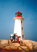 Vue générale du phare de Peggy's Cove, mettant en évidence la corniche de forme octogonale, élégamment courbée, et le couronnement des fenêtres empruntant à l’esthétique moderne, 2001.; Department of Fisheries & Oceans Canada | Département de pêches et océans Canada, 2001.